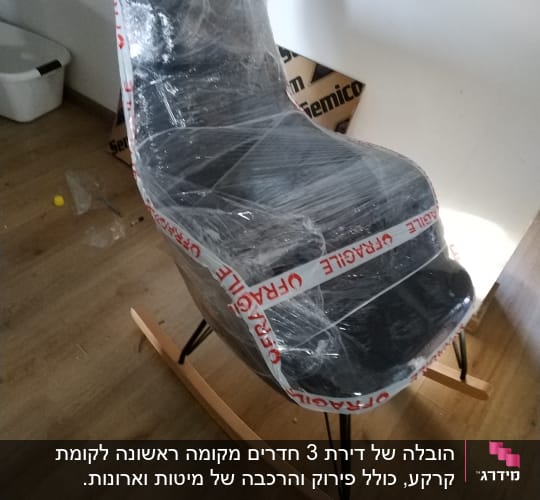 כיסא נדנדה עטוף בניילון עם סרט "שביר"